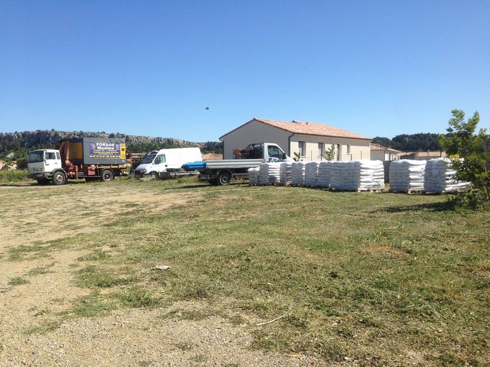 forage maxime - camionnettes et camion de pompage devant une habitation