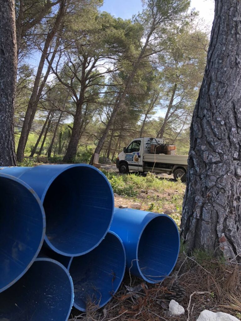 forage maxime - tuyaux au premier plan avec en second plan une camionnette de chantier de forage maxime